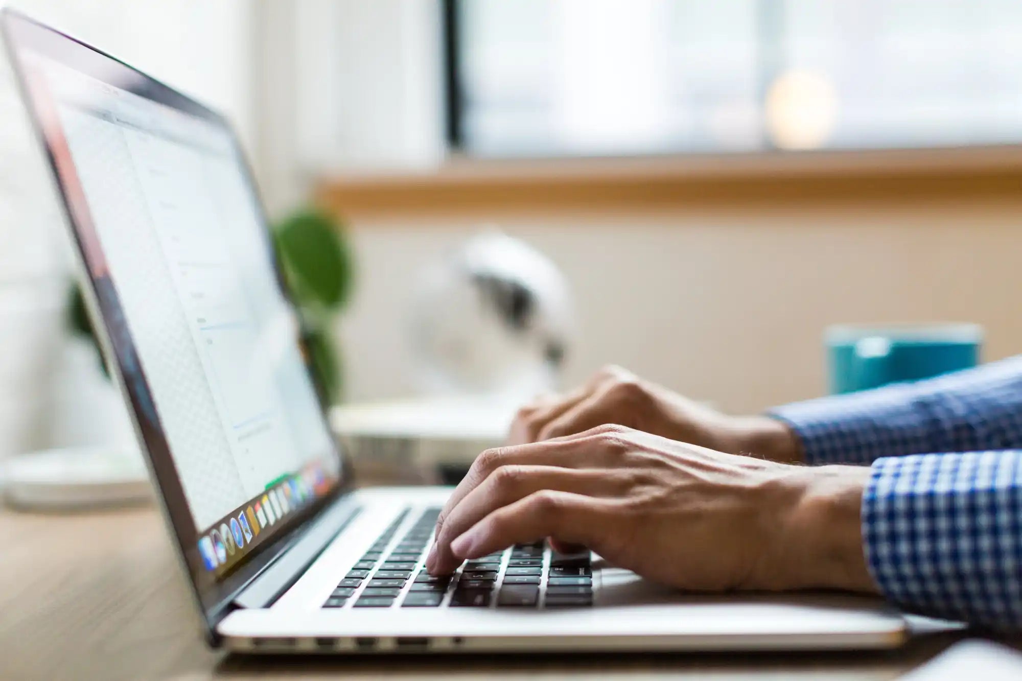 Silver laptop with hands typing.